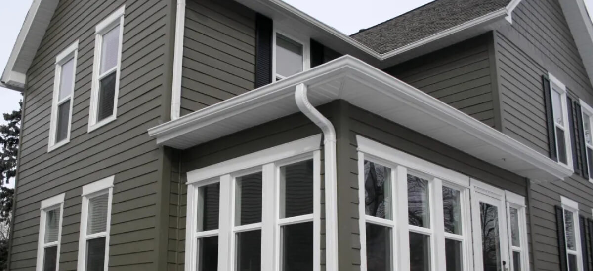 alt= A view of painted cement siding on a Vermont house.